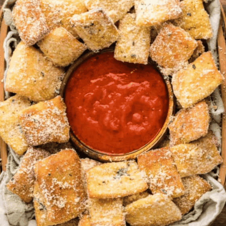A bowl of homemade Domino’s-style pizza sauce with fresh herbs nearby