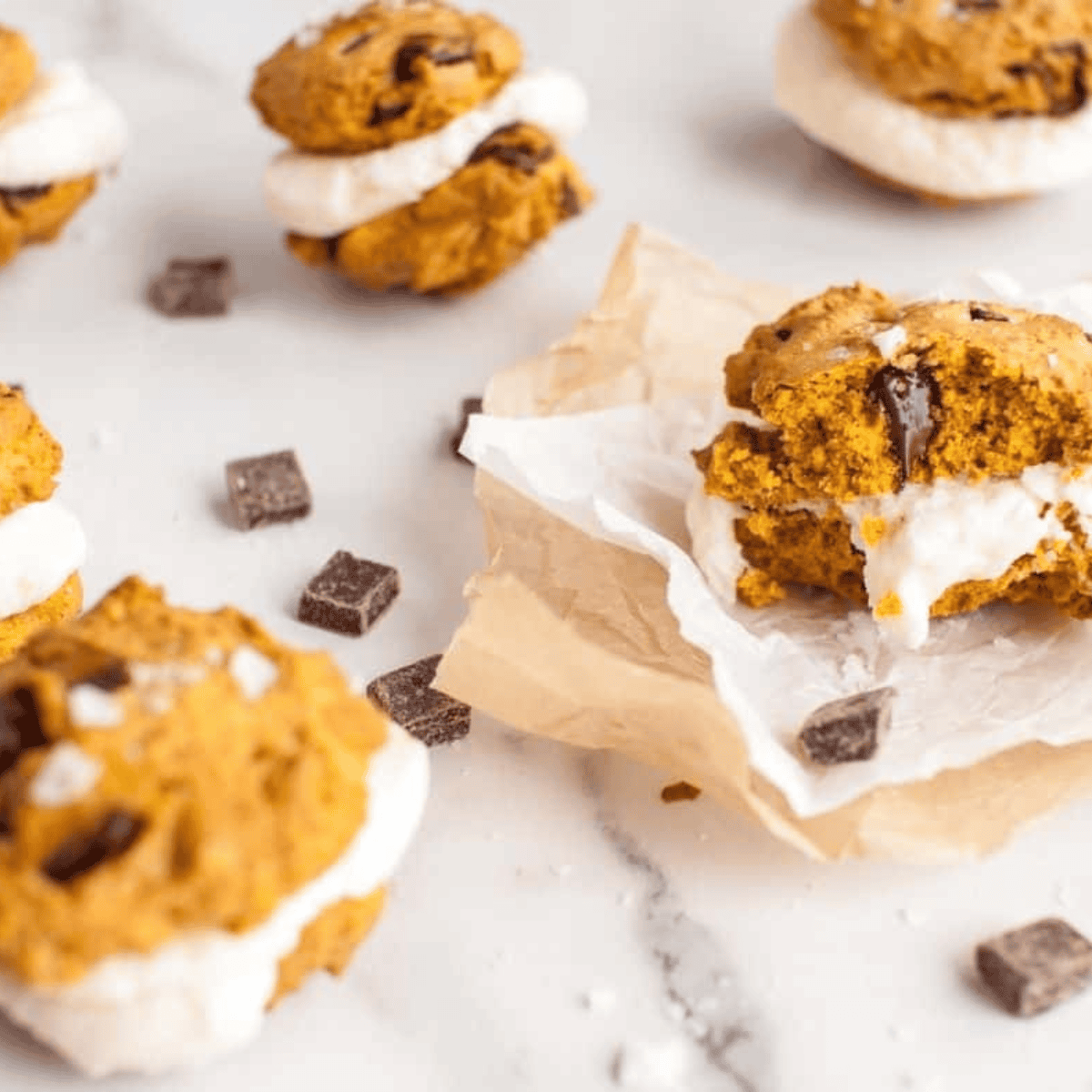 Pumpkin chocolate chunk sandwich cookies fresh from the air fryer, soft and filled with melty chocolate pieces.