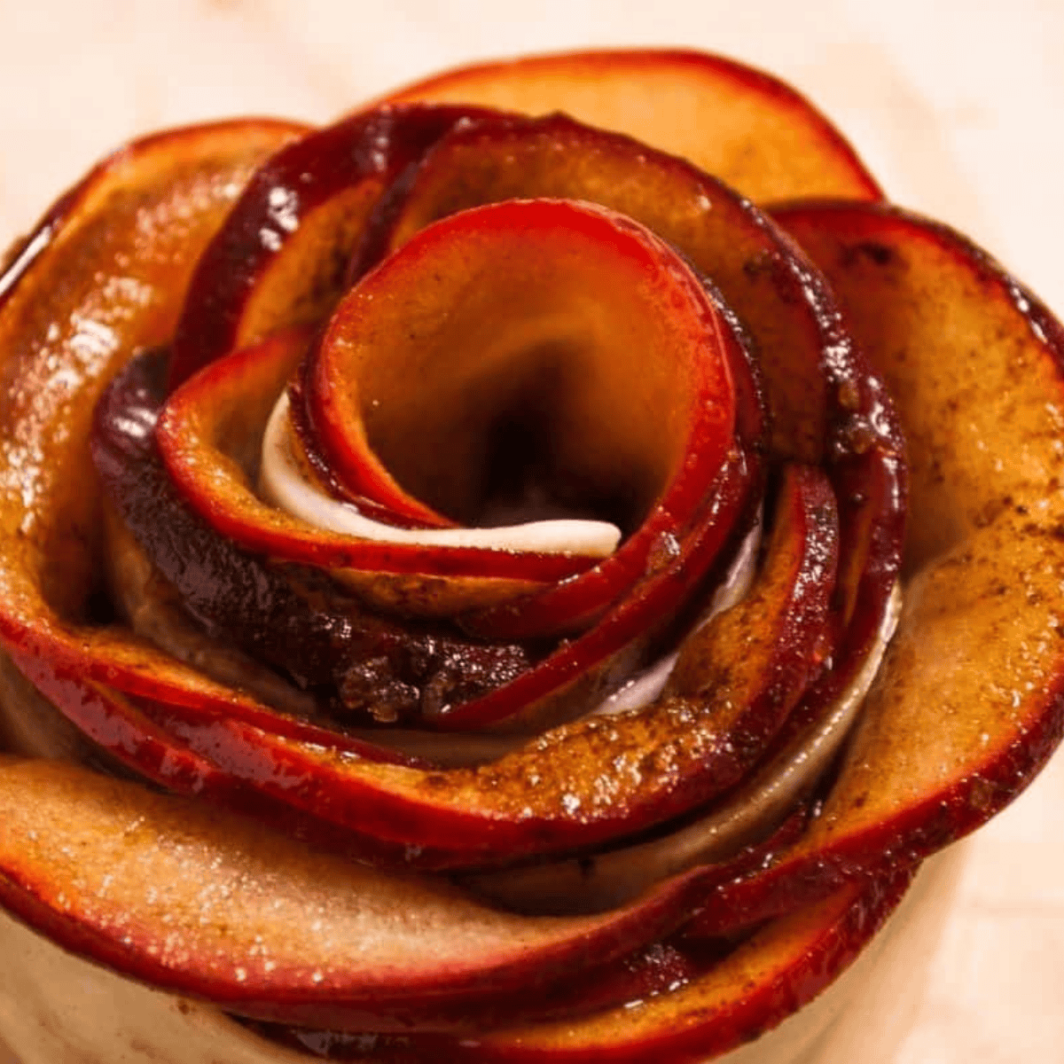 Apple slices fanned along a puff pastry strip before rolling into a rose