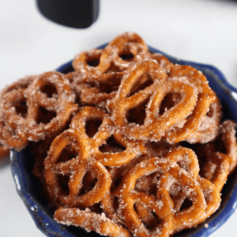 Bowl of golden air fryer cinnamon sugar pretzels coated in cinnamon and sugar.
