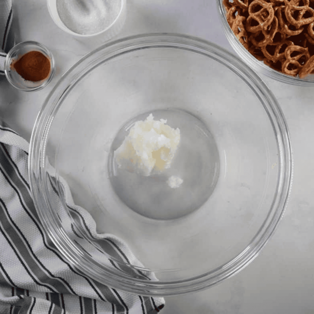 Melted coconut oil, sugar, and cinnamon stirred together in a bowl for cinnamon sugar pretzels.