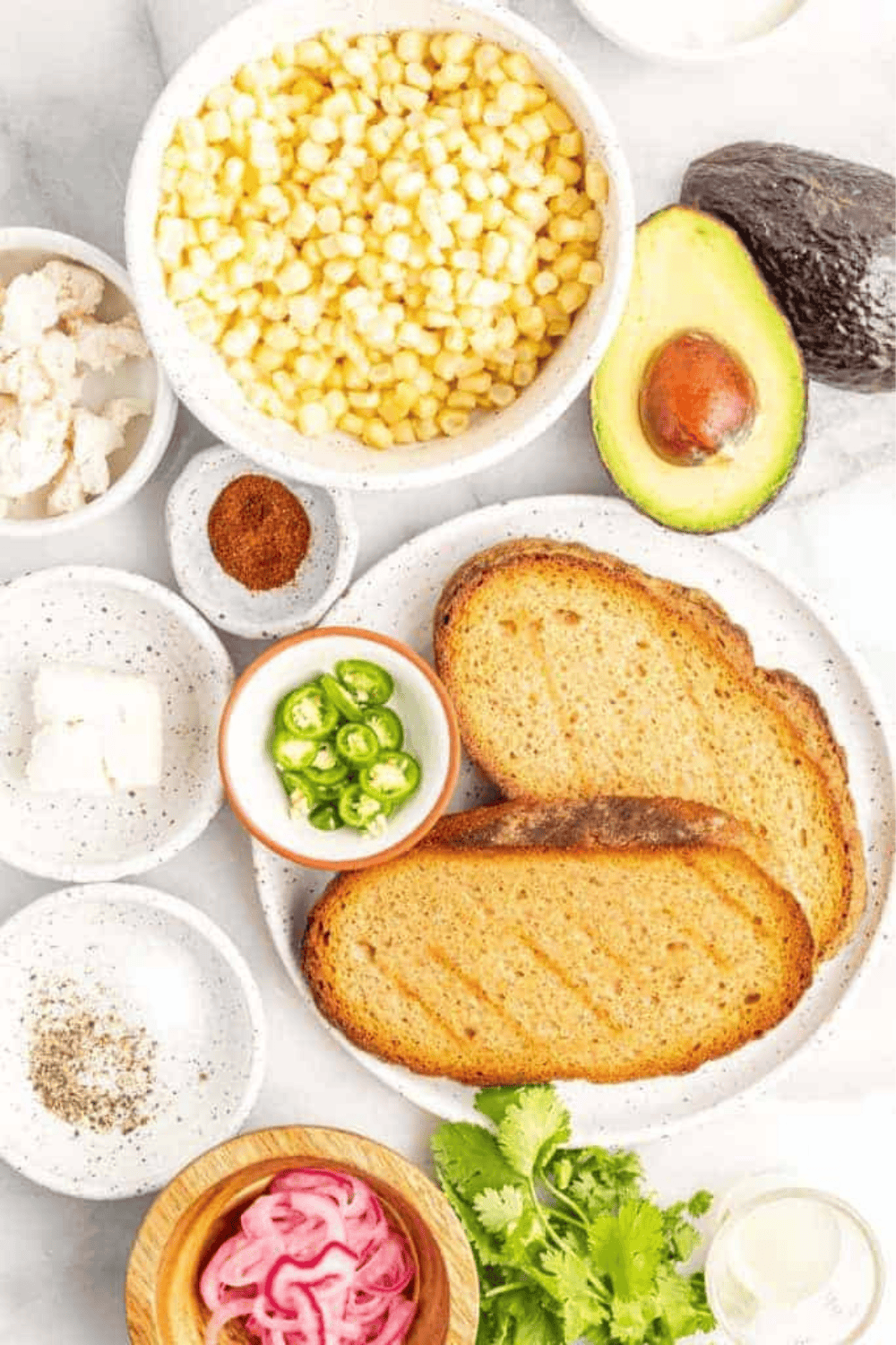 Ingredients needed for Air Fryer Elote Avocado Toast on kitchen table.