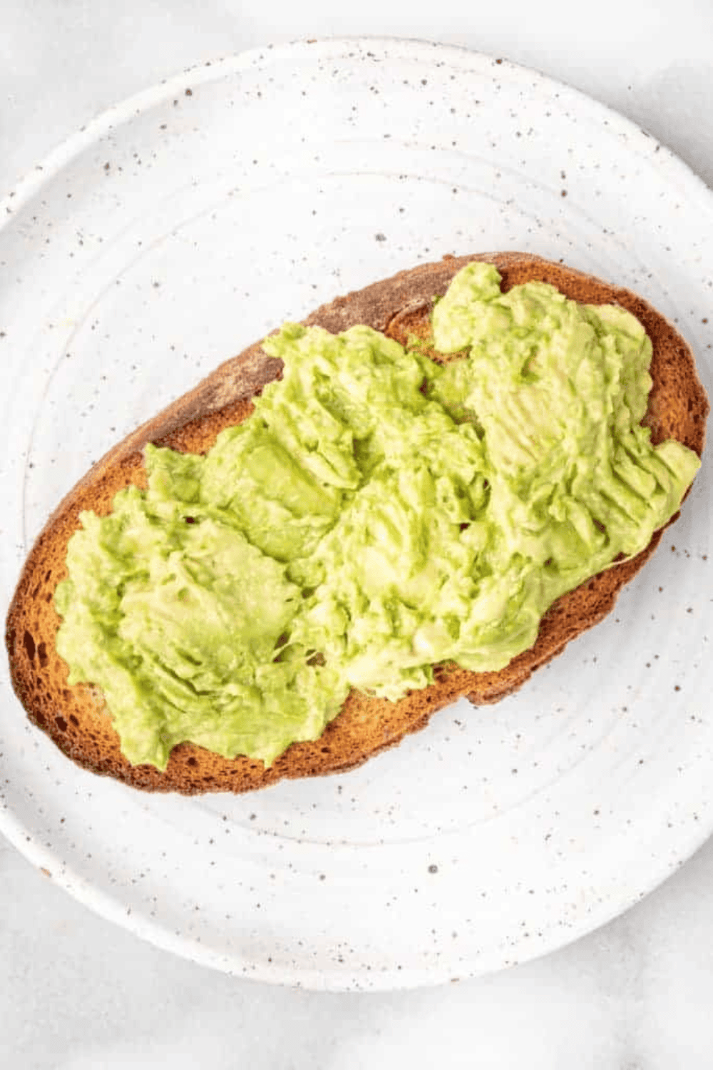 avocado spread on toast topped with corn, cotija, onions, and chili powder