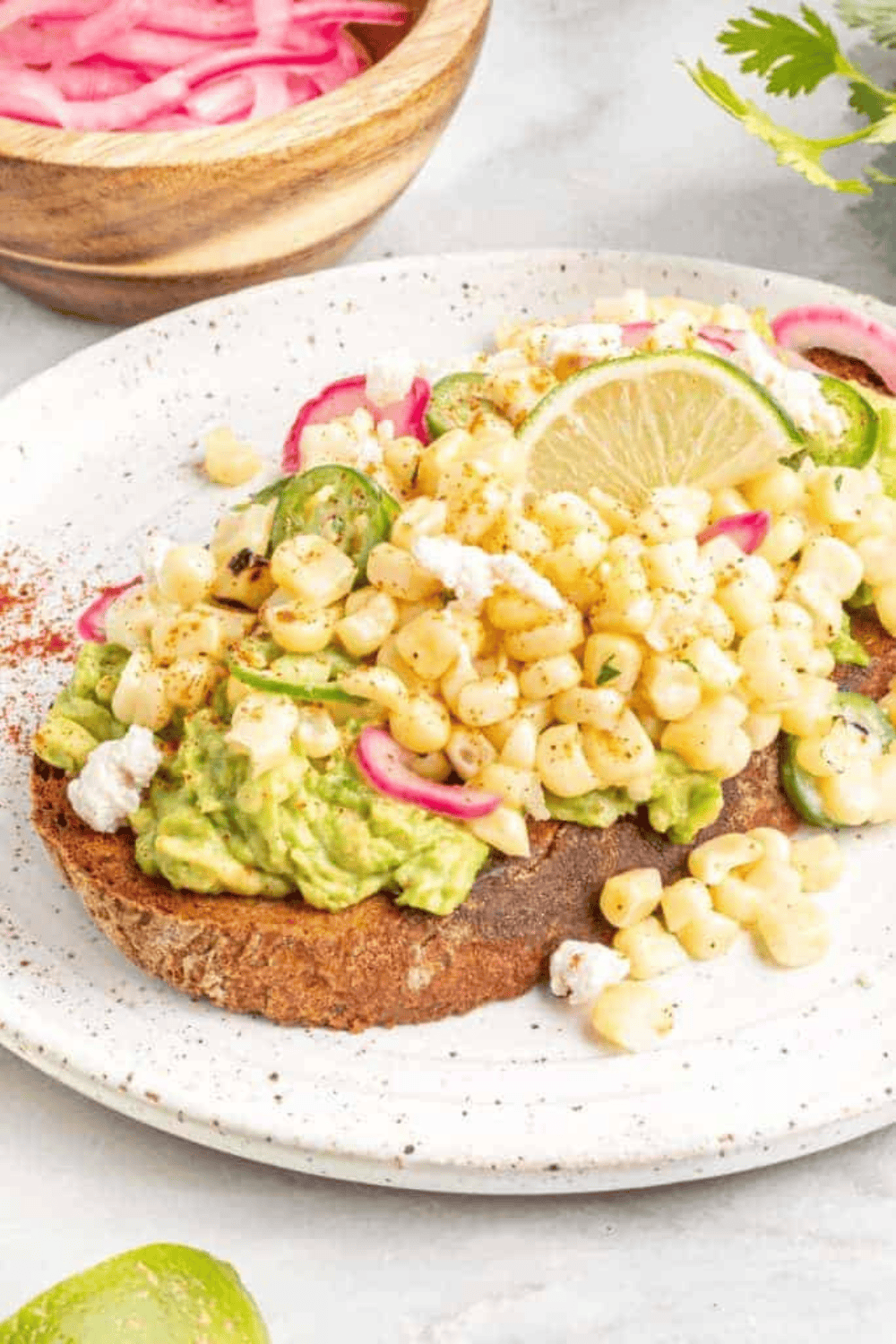air fryer elote avocado toast with corn, cotija, lime, and cilantro
