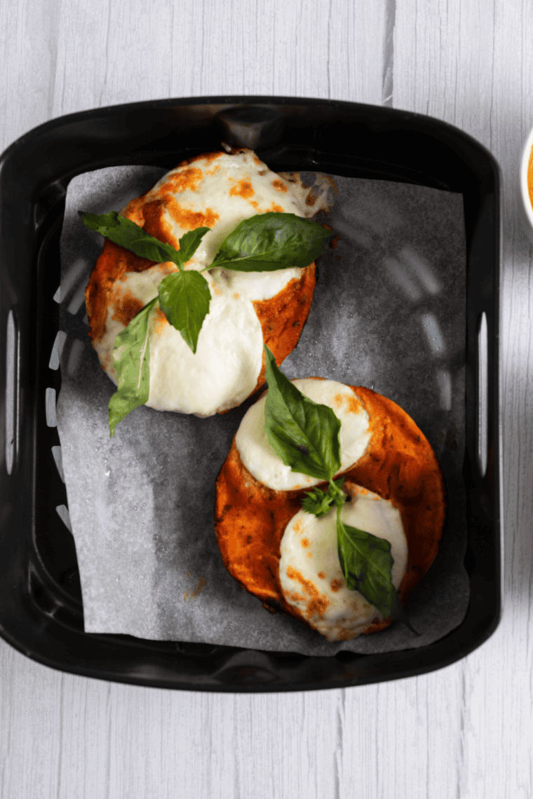 Air fryer Margherita pizza bagels with melted cheese, basil, and marinara sauce.