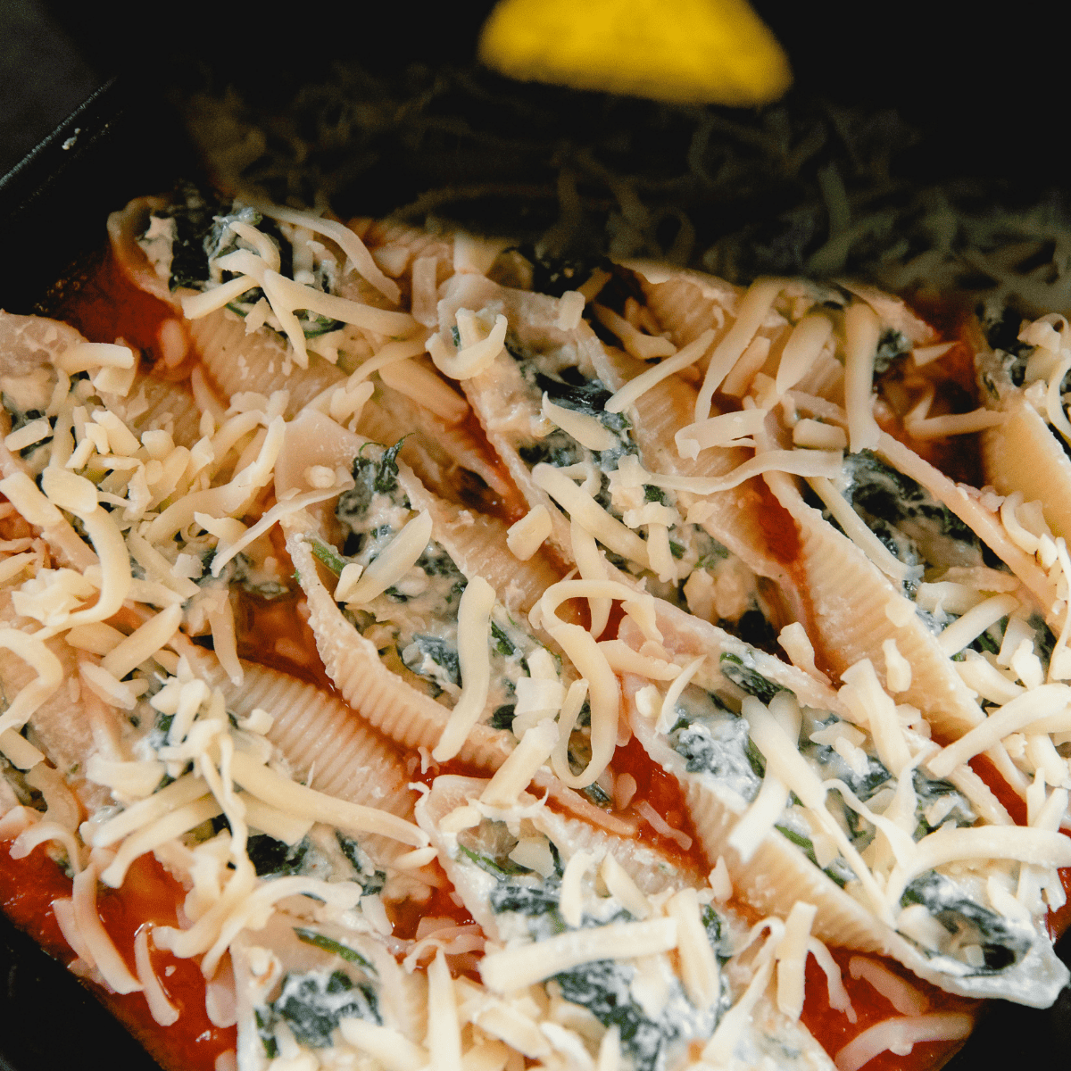 Air fryer stuffed spinach pasta shells cooking until the cheese is melted and bubbly