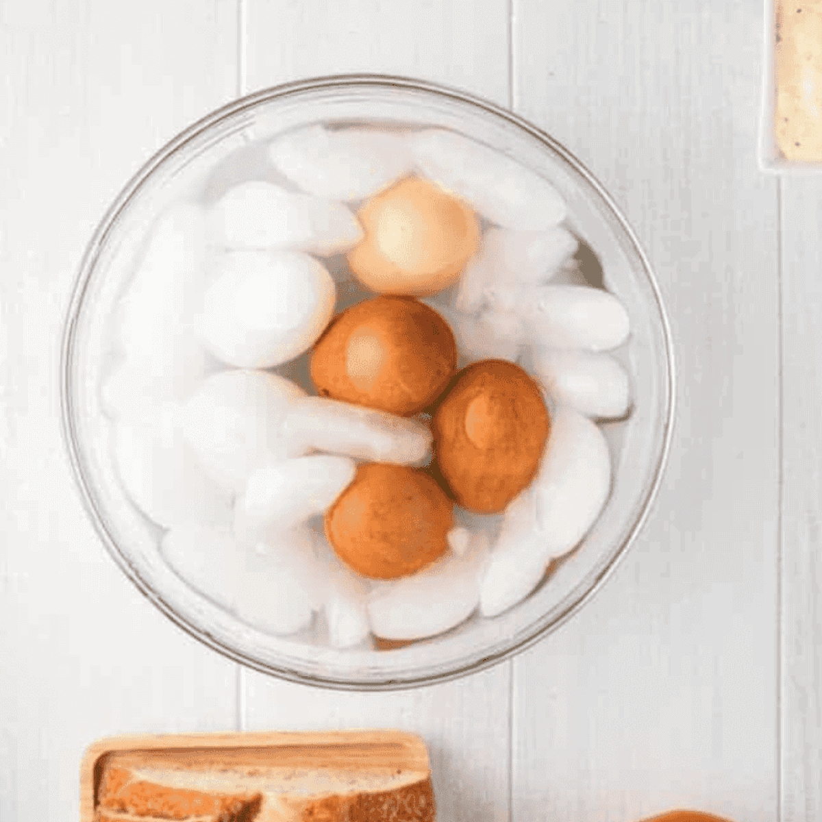 Hard-boiled eggs cooling in an ice bath after cooking in the air fryer at 250°F for 15 minutes.
