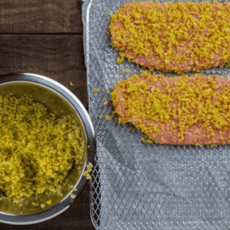 Three-step breading process: dipping veal cutlets in egg, then fully coating them in breadcrumbs.