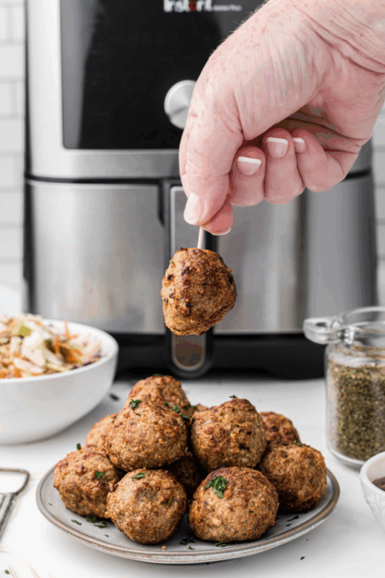 Juicy spicy turkey meatballs garnished with fresh parsley, served on a plate.