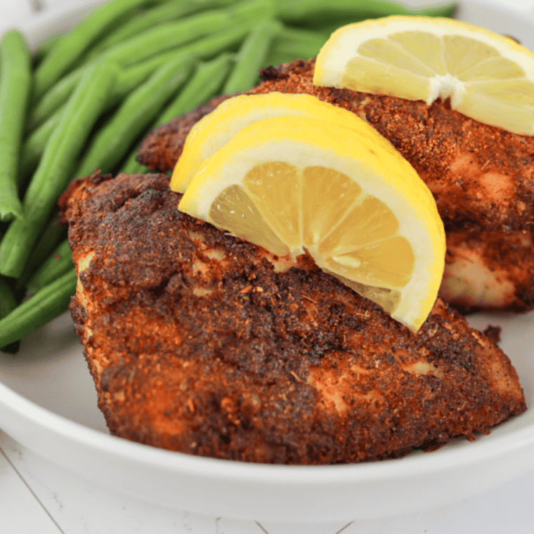 Air fryer red snapper fillet, golden and flaky, garnished with lemon and fresh herbs