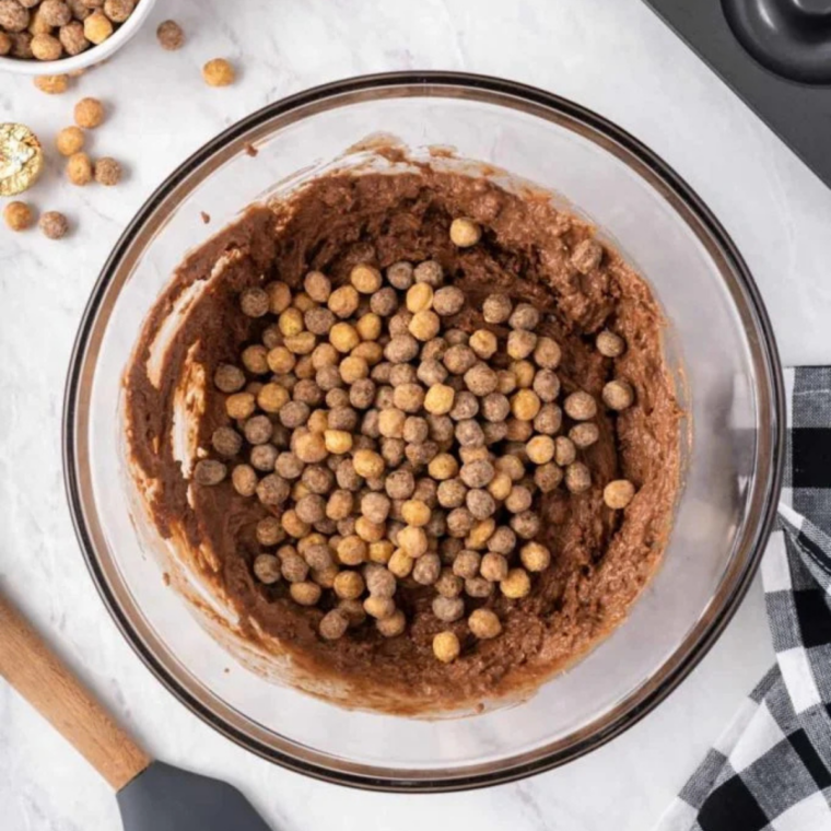 Thick, lumpy chocolate donut batter with whole Reese's Puffs cereal folded in
