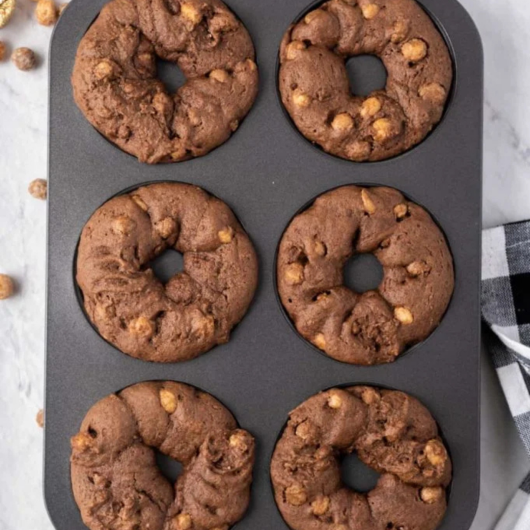 Baked chocolate donuts cooling on a wire rack after air frying at 320 degrees