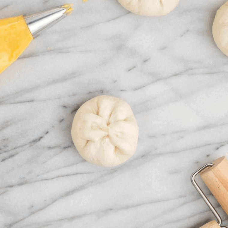Sealing biscuit dough around Bavarian cream filling before cooking