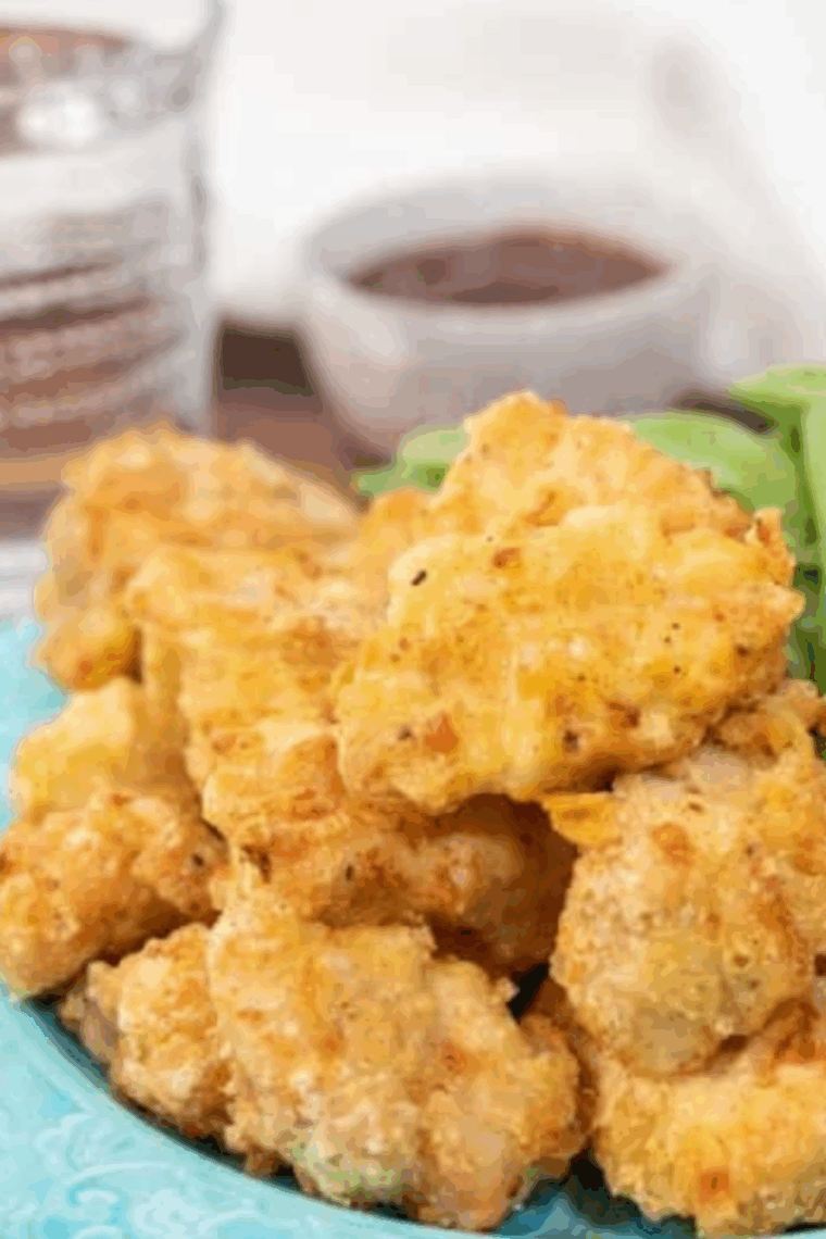 Golden, crispy Air Fryer Chinese Chicken Fingers on a plate with a small bowl of dipping sauce.