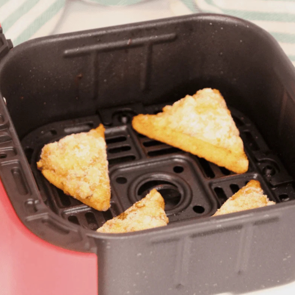 Frozen shrimp toast arranged in a single layer in the air fryer basket before cooking