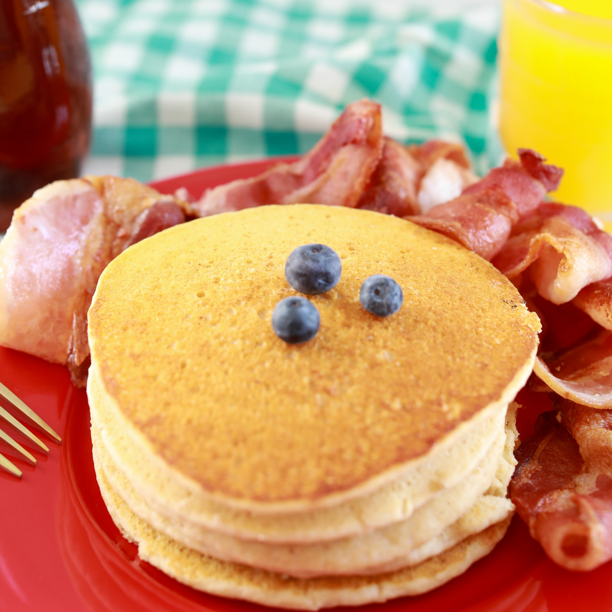 Reheated pancakes stacked on plate with butter and maple syrup