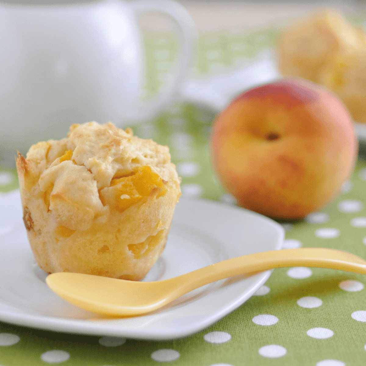 Golden air fryer peach muffins with soft, fluffy centers and juicy peach chunks, freshly baked and ready to enjoy.