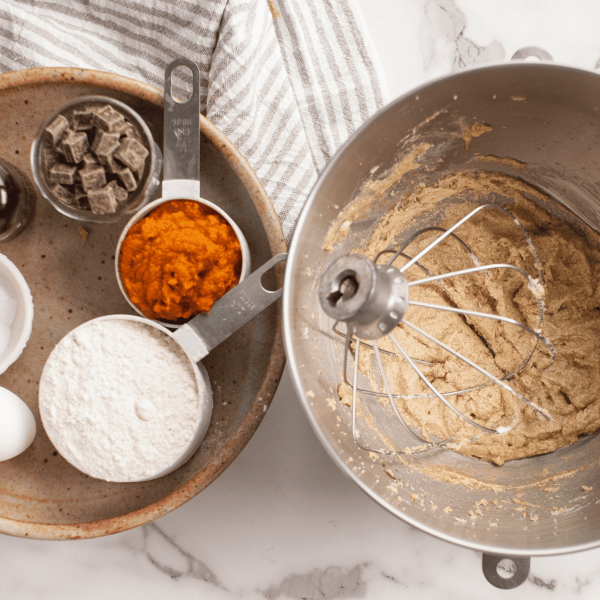 Mixing pumpkin cake mix, puree, butter, and eggs in a bowl.