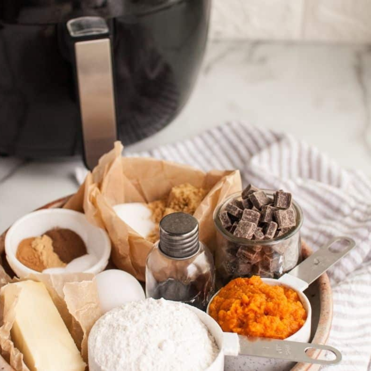 Ingredients for air fryer pumpkin layer cake including pumpkin puree, flour, eggs, and spices