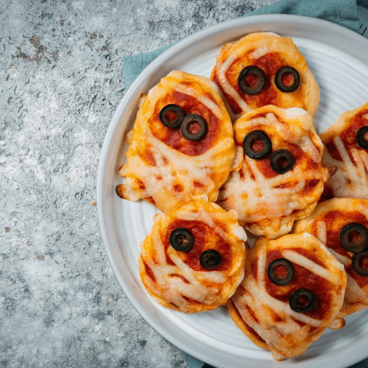 Easy air fryer mummy pizza topped with cheese strips and olive eyes for Halloween kids recipe