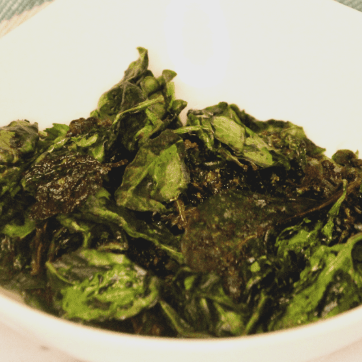 Golden, crispy air fryer spinach chips served in a bowl, ready to enjoy.