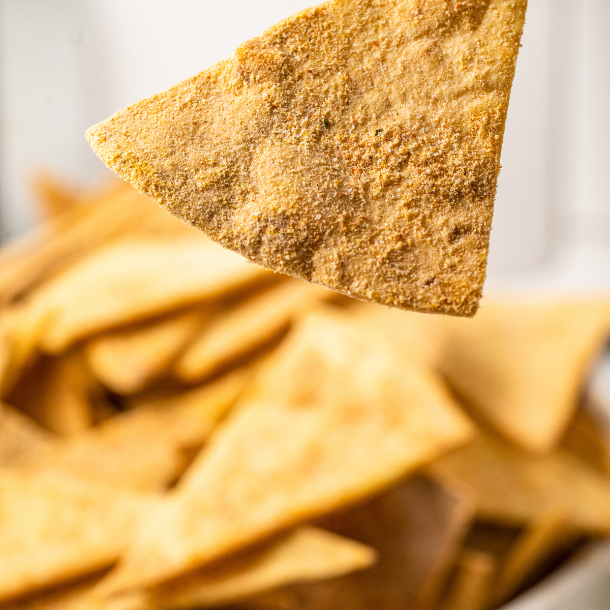 Golden crispy air fryer taco tortilla chips piled in a bowl with salsa