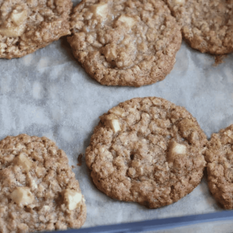 Air fryer apple cinnamon oatmeal cookies spaced on parchment paper, cooling on wire rack after 6–8 minute air frying.