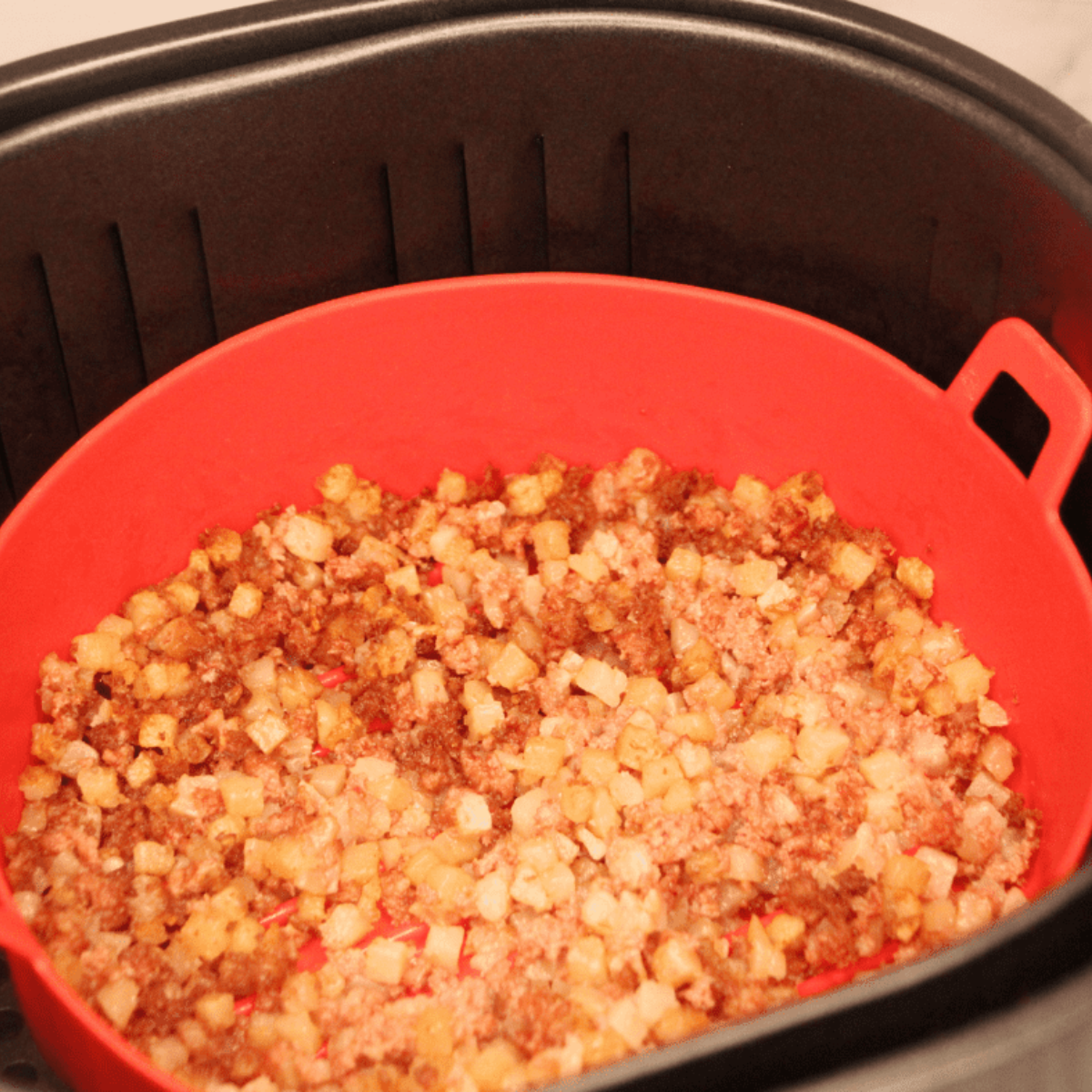 Air fryer corned beef hash cooking to golden crispy finish