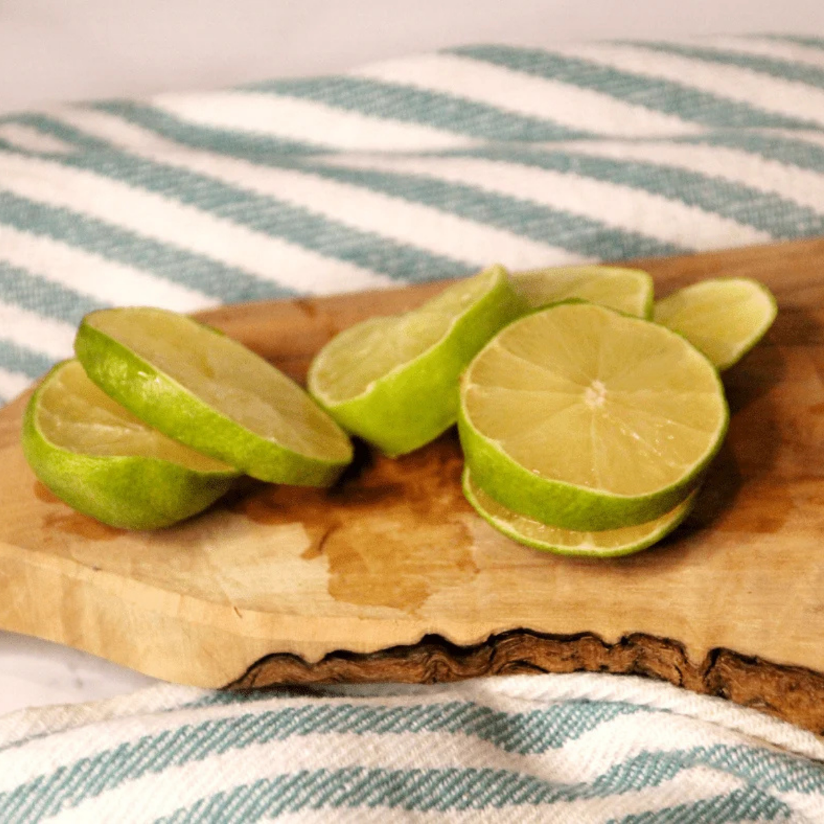 Fresh limes sliced thinly on a mandoline for dehydrating.