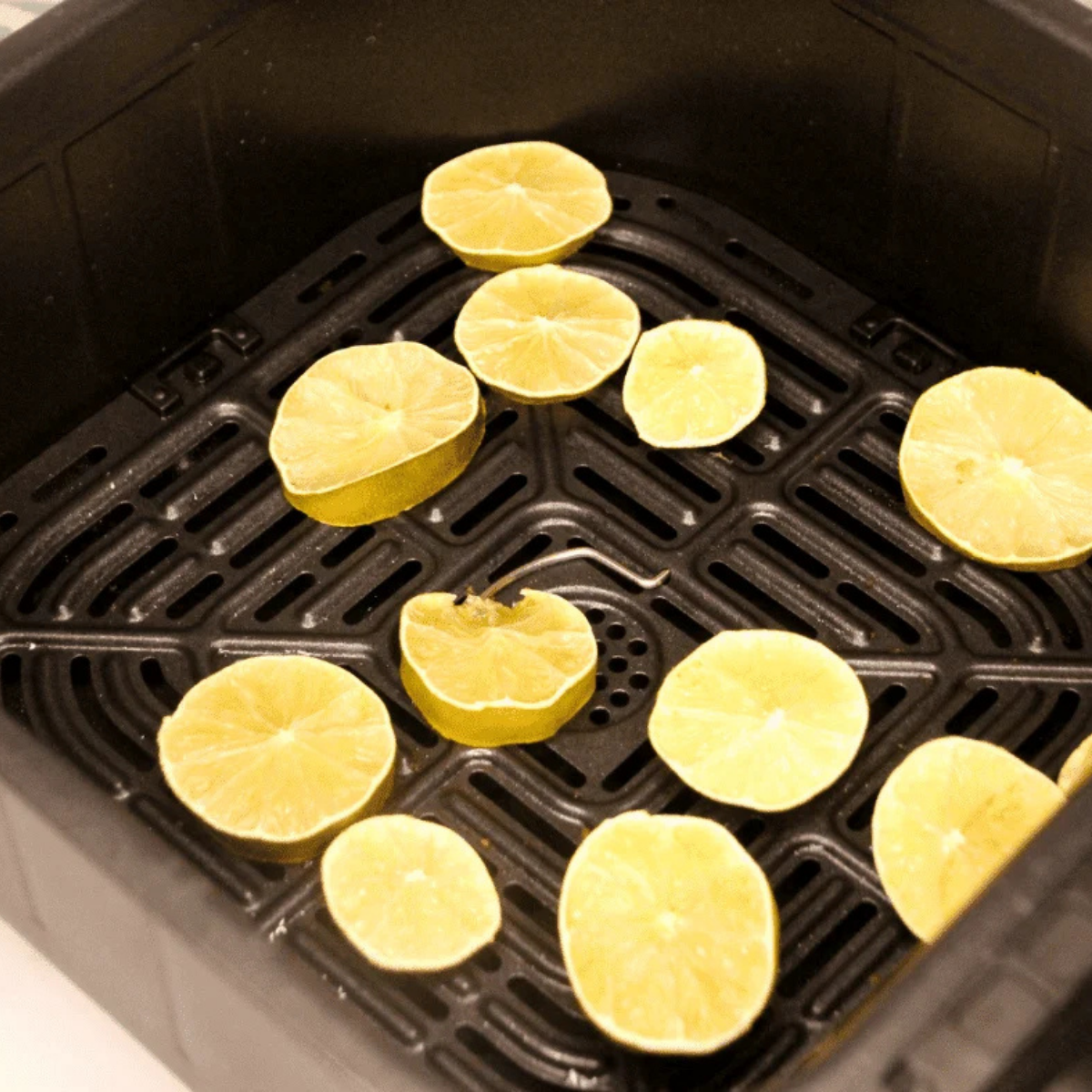 Lime slices arranged in a single layer in the air fryer basket