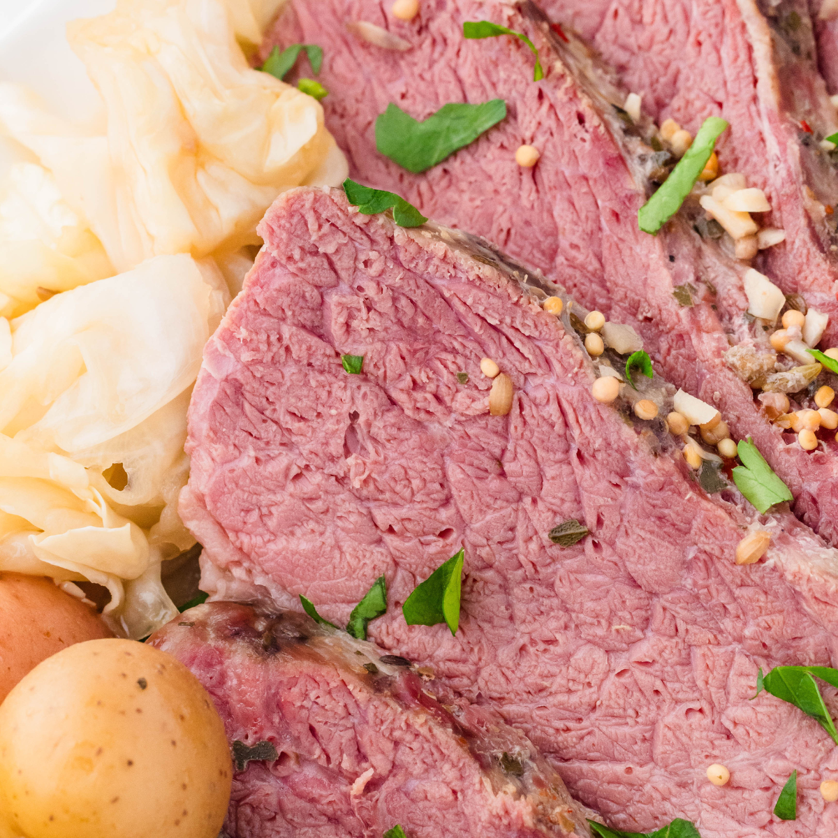 Sliced corned beef brisket cooked in an air fryer with crispy edges and juicy center served on a cutting board.