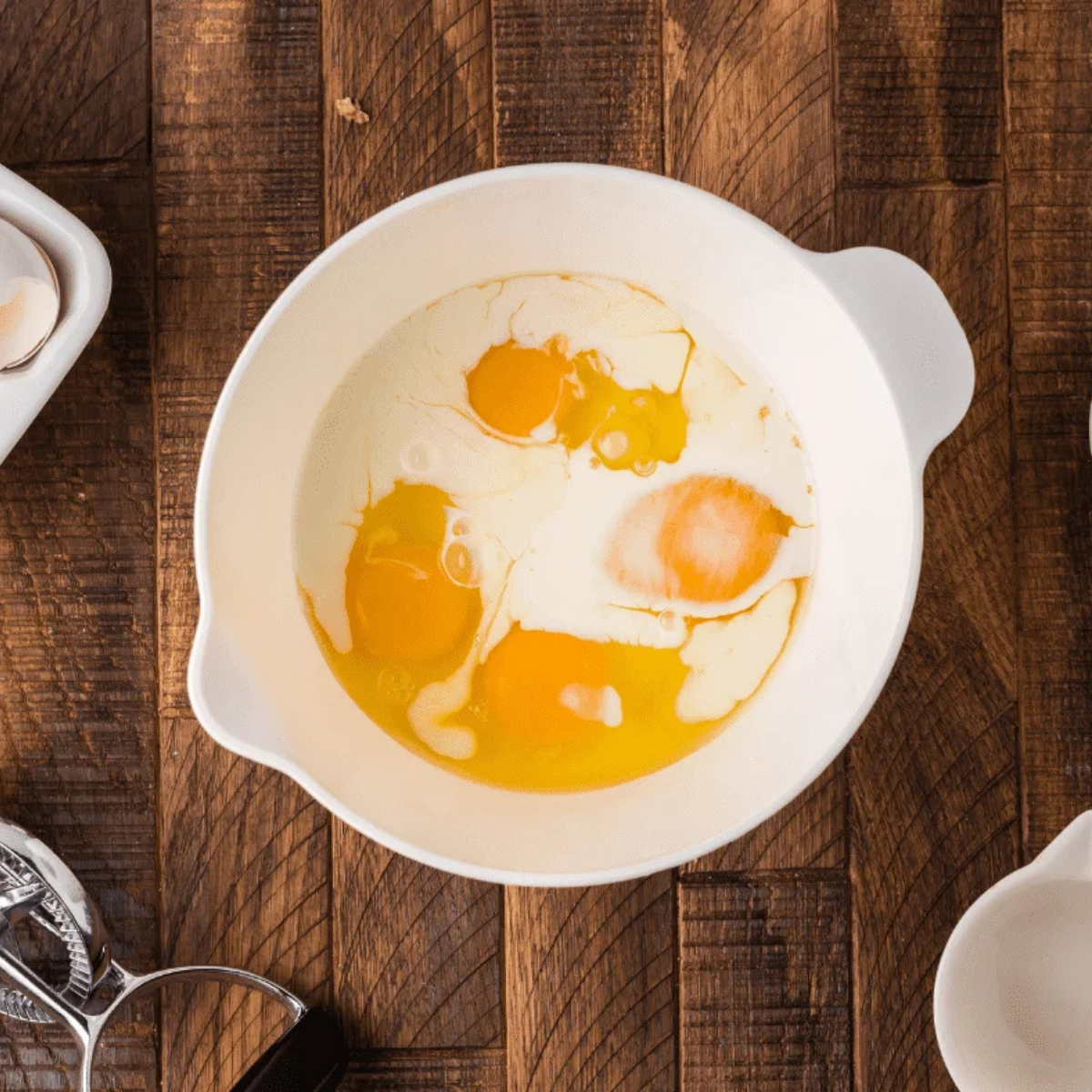 Whisked eggs, milk, salt, and pepper blended in a bowl before cooking