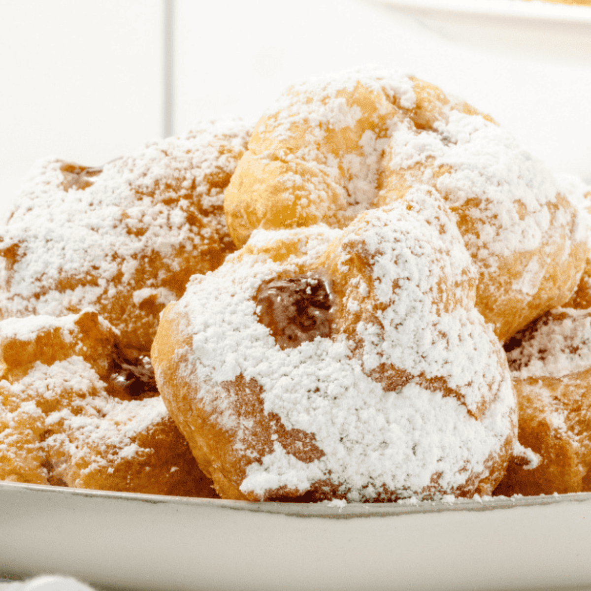 Fluffy air fryer Israeli sufganiyot donuts with jelly filling and powdered sugar.