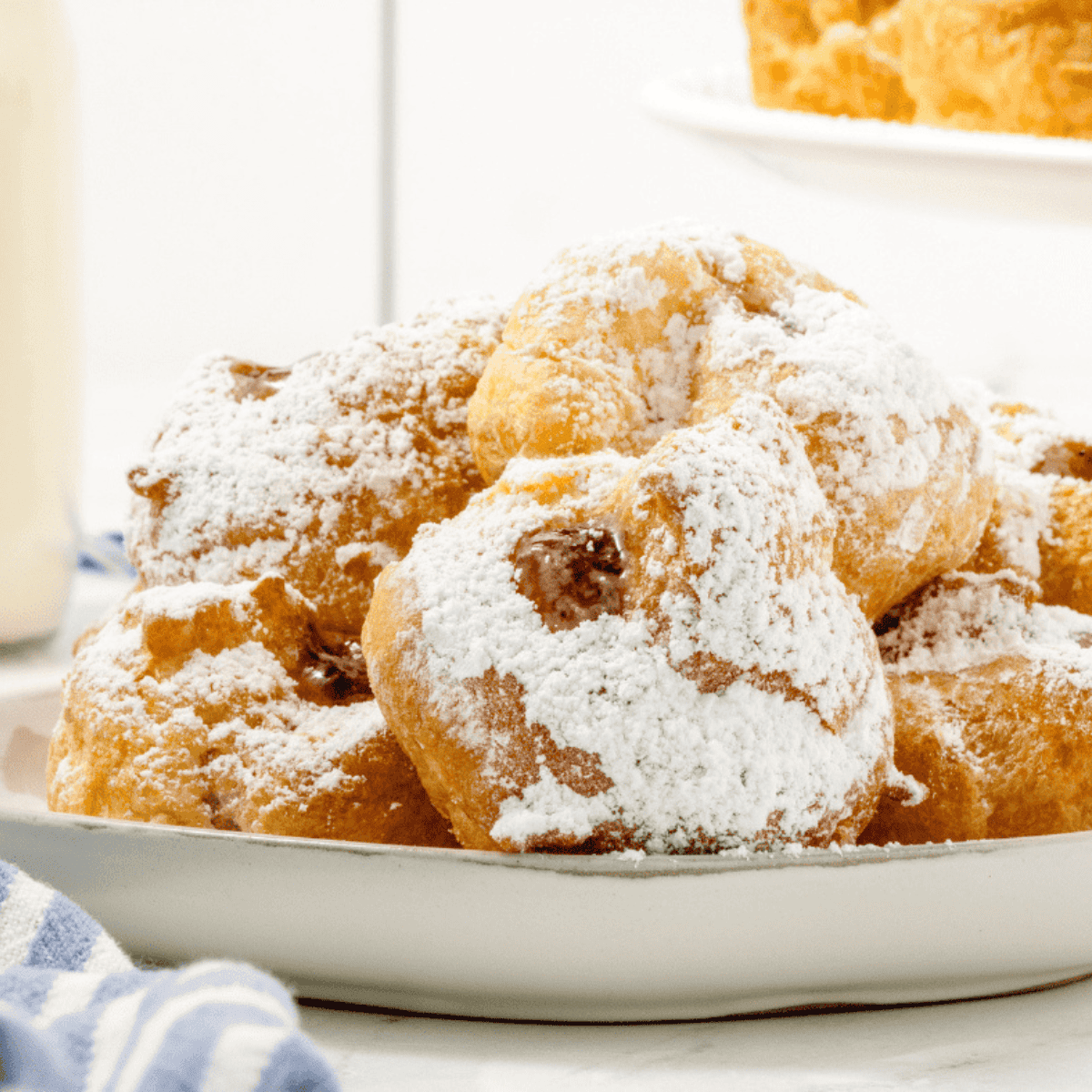 Golden air fryer sufganiyot filled with jelly and dusted with powdered sugar.
