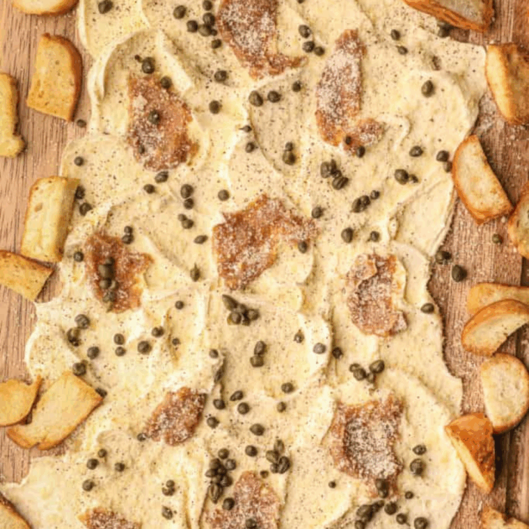 Vibrant TikTok butter board decorated with herbs, spices, and toppings.