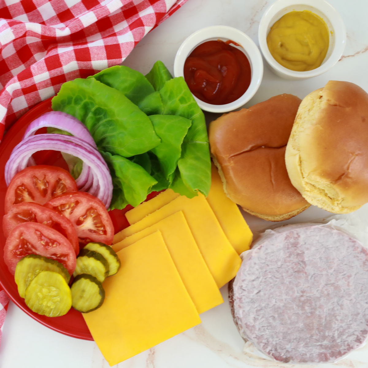 Ingredients for cooking air fryer Bubba burgers laid out on a wood board.