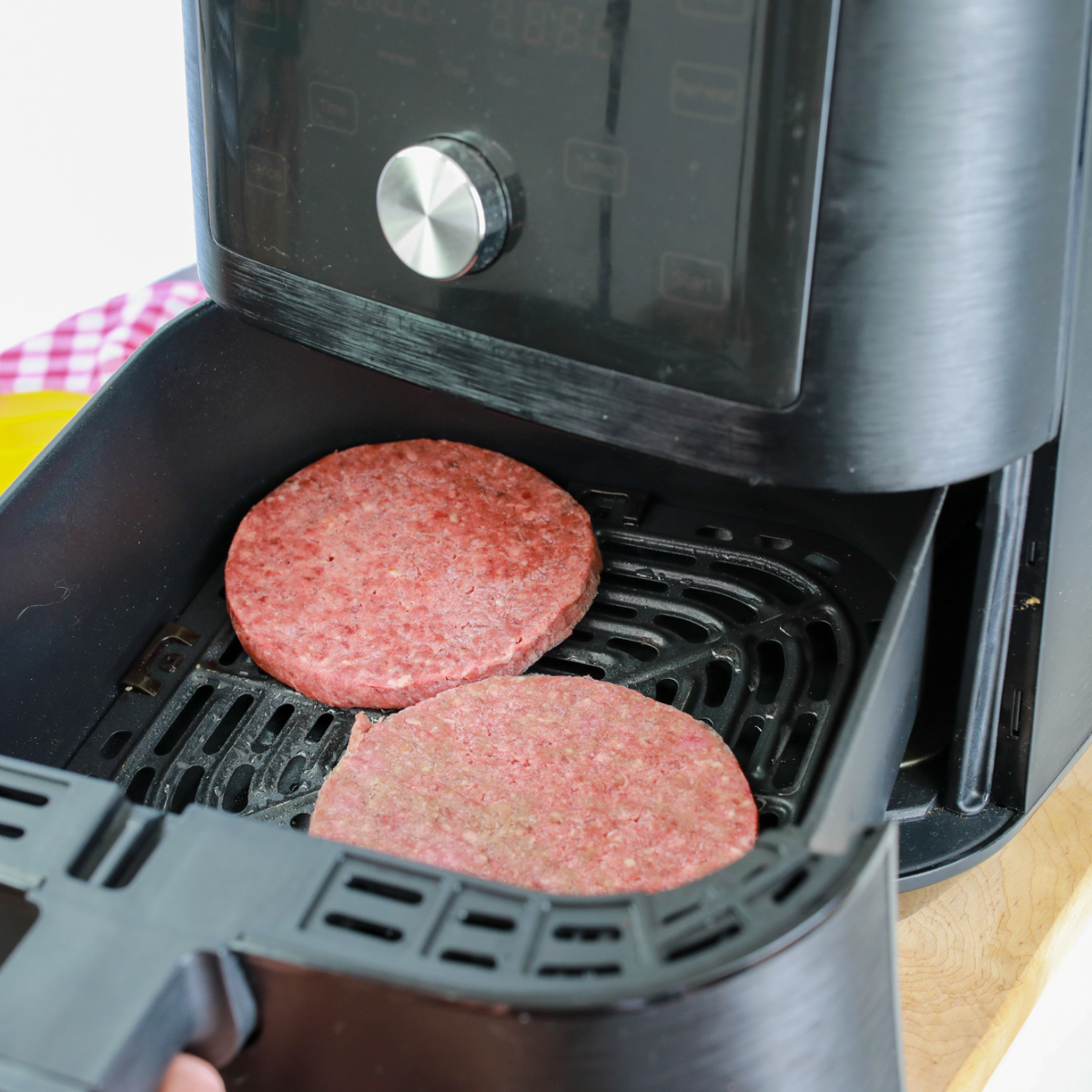 Frozen Bubba burger patties arranged in a single layer in an air fryer basket.: