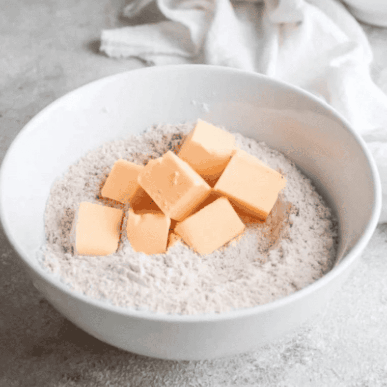 Ingredients for air fryer cheese scones: flour, cheddar, butter, milk, and baking powder.