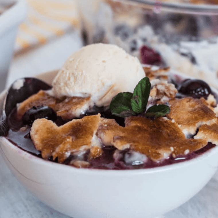 Moist blueberry cake made in an Instant Pot topped with fresh blueberries and light glaze, served on a plate for a quick homemade dessert.