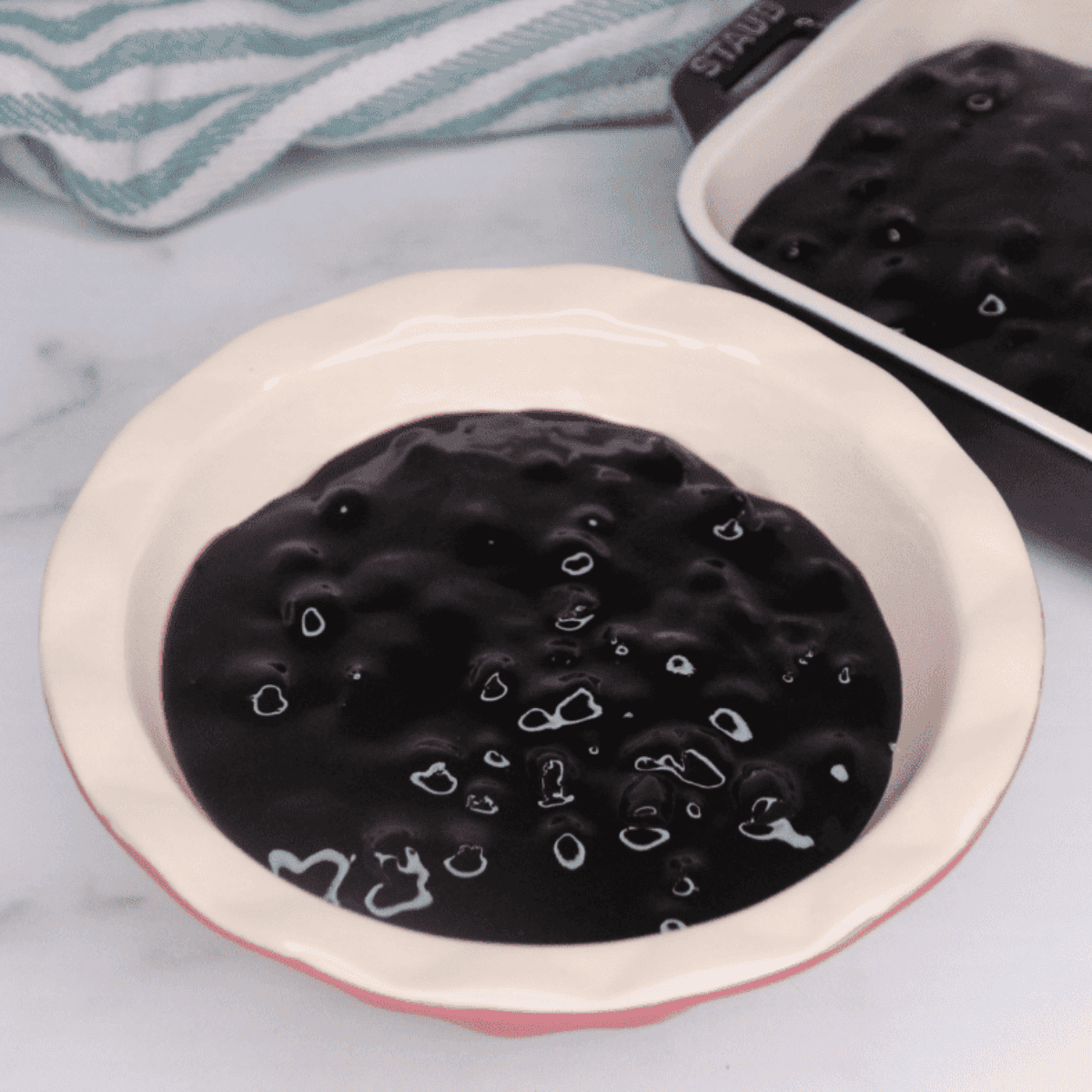Grease ramekins or casserole dish, then spread blueberry pie filling evenly on the bottom.