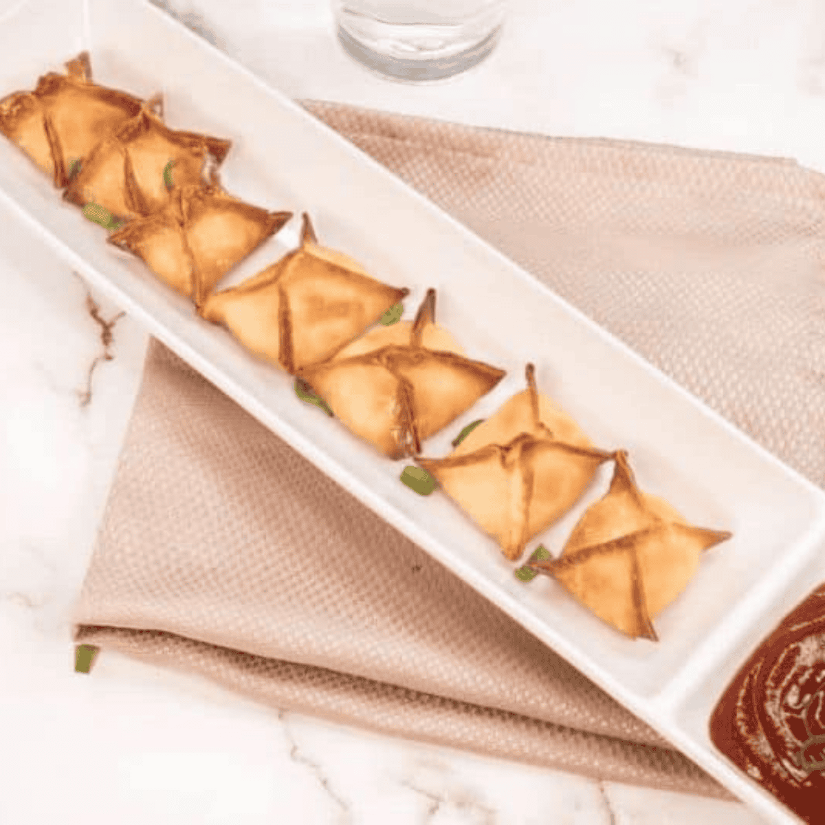 Air fryer basket filled with crab rangoon reheating until golden brown and crispy, showing crunchy wonton wrappers and creamy filling inside.