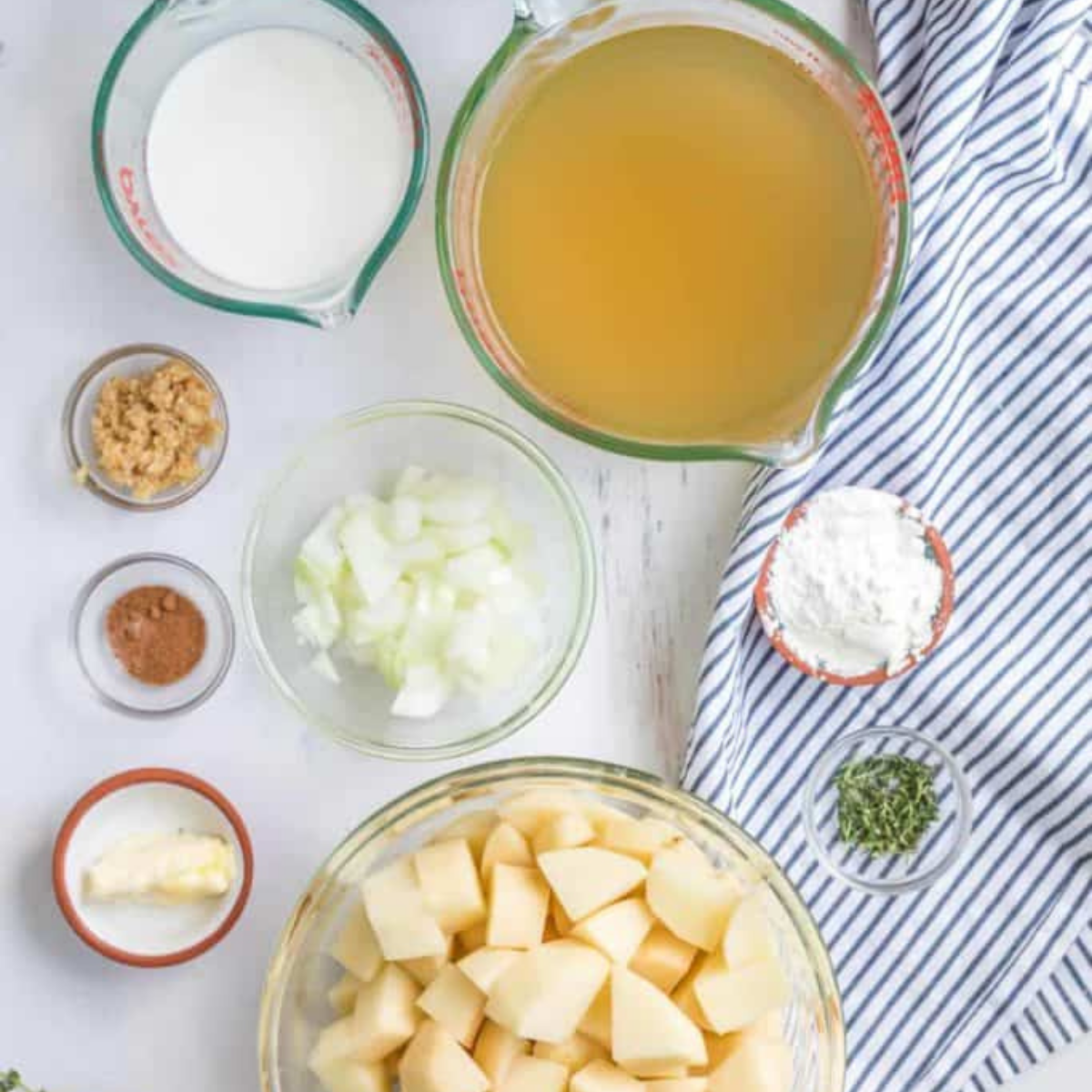 Russet potatoes, milk, garlic salt, and green onions on a countertop