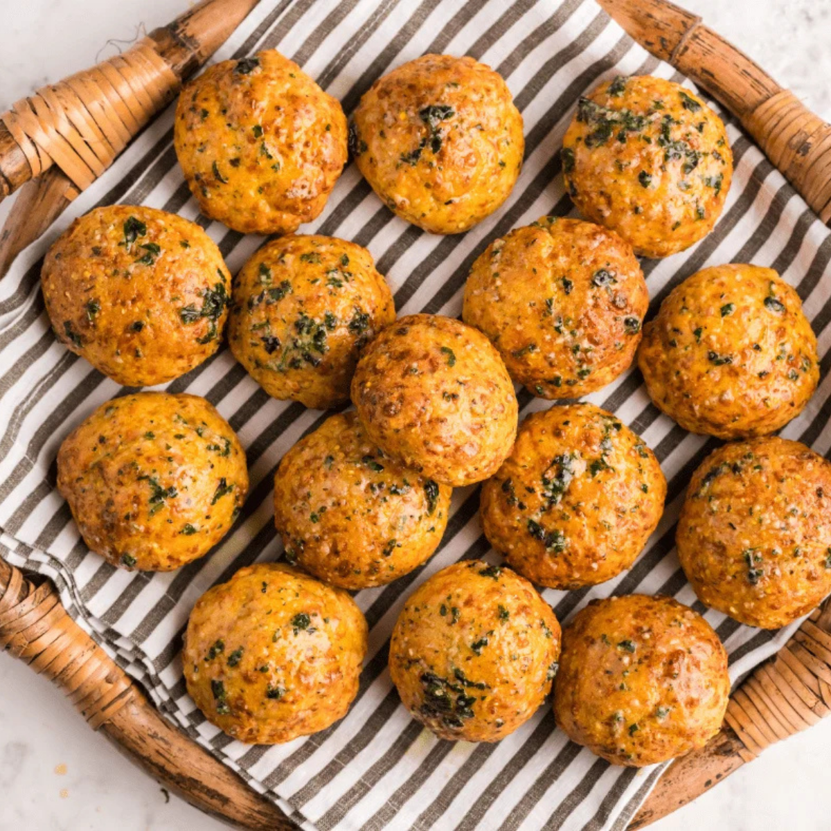 Air fryer cheese puffs rising and turning golden brown in the air fryer basket