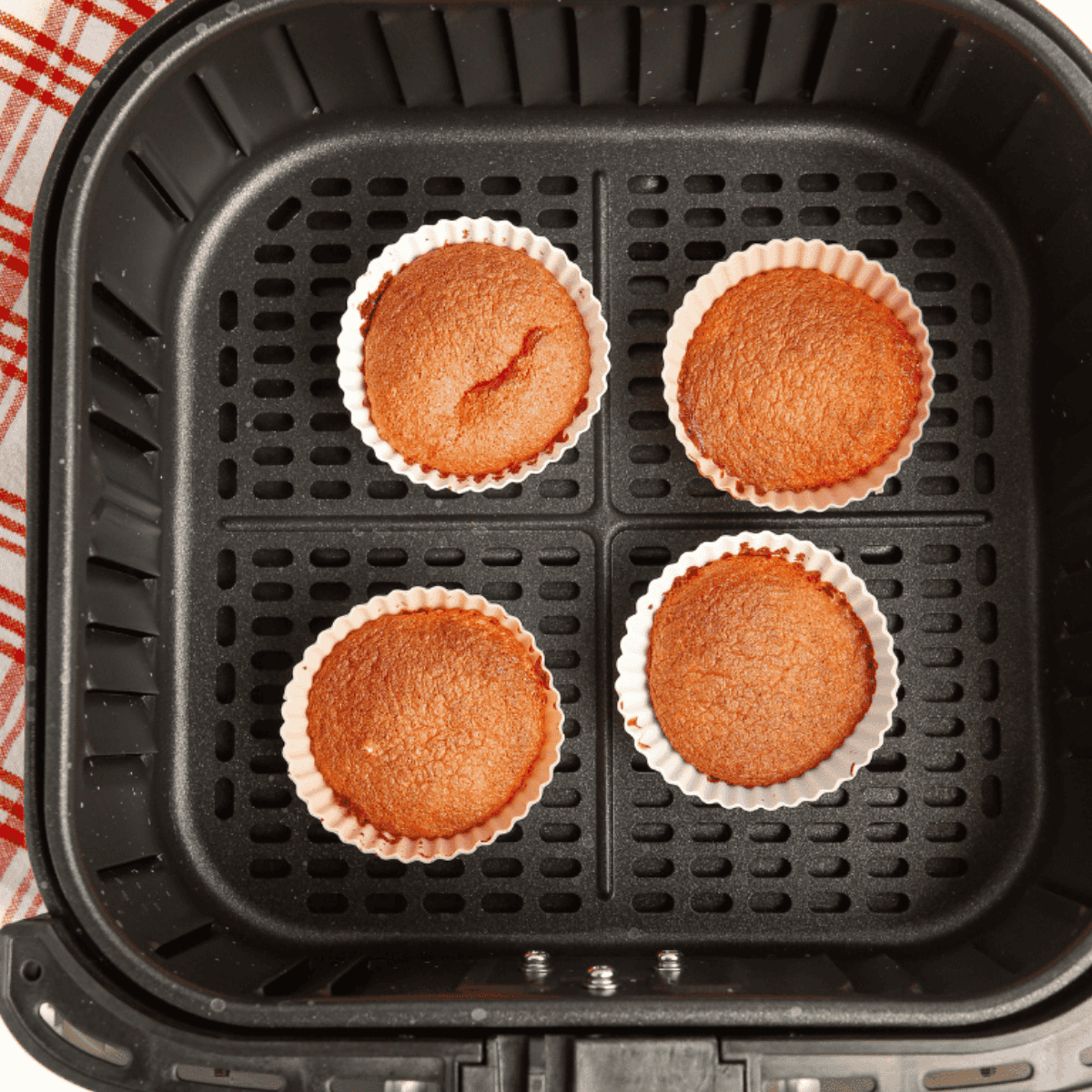 Baked strawberry cupcakes cooling inside the air fryer basket.