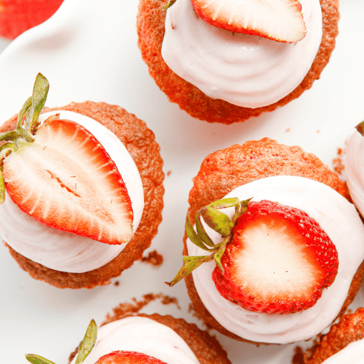 Frosted air fryer strawberry cupcakes topped with strawberry cream cheese frosting.