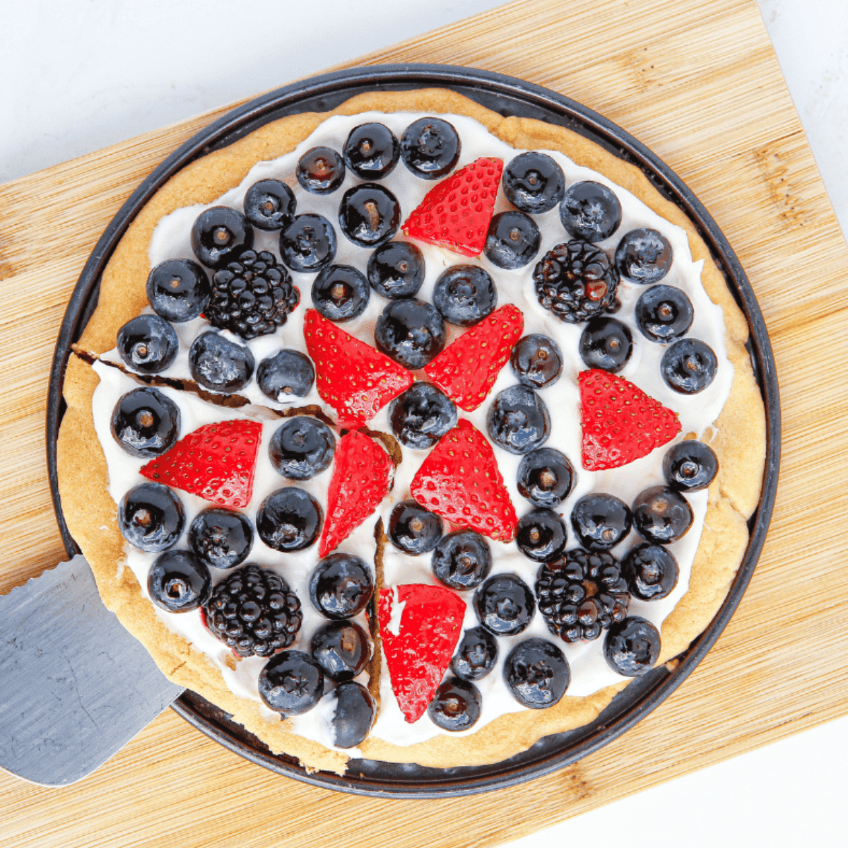 Air Fryer Sugar Fruit Pizza with golden cookie crust, creamy frosting, and vibrant fresh fruit toppings.