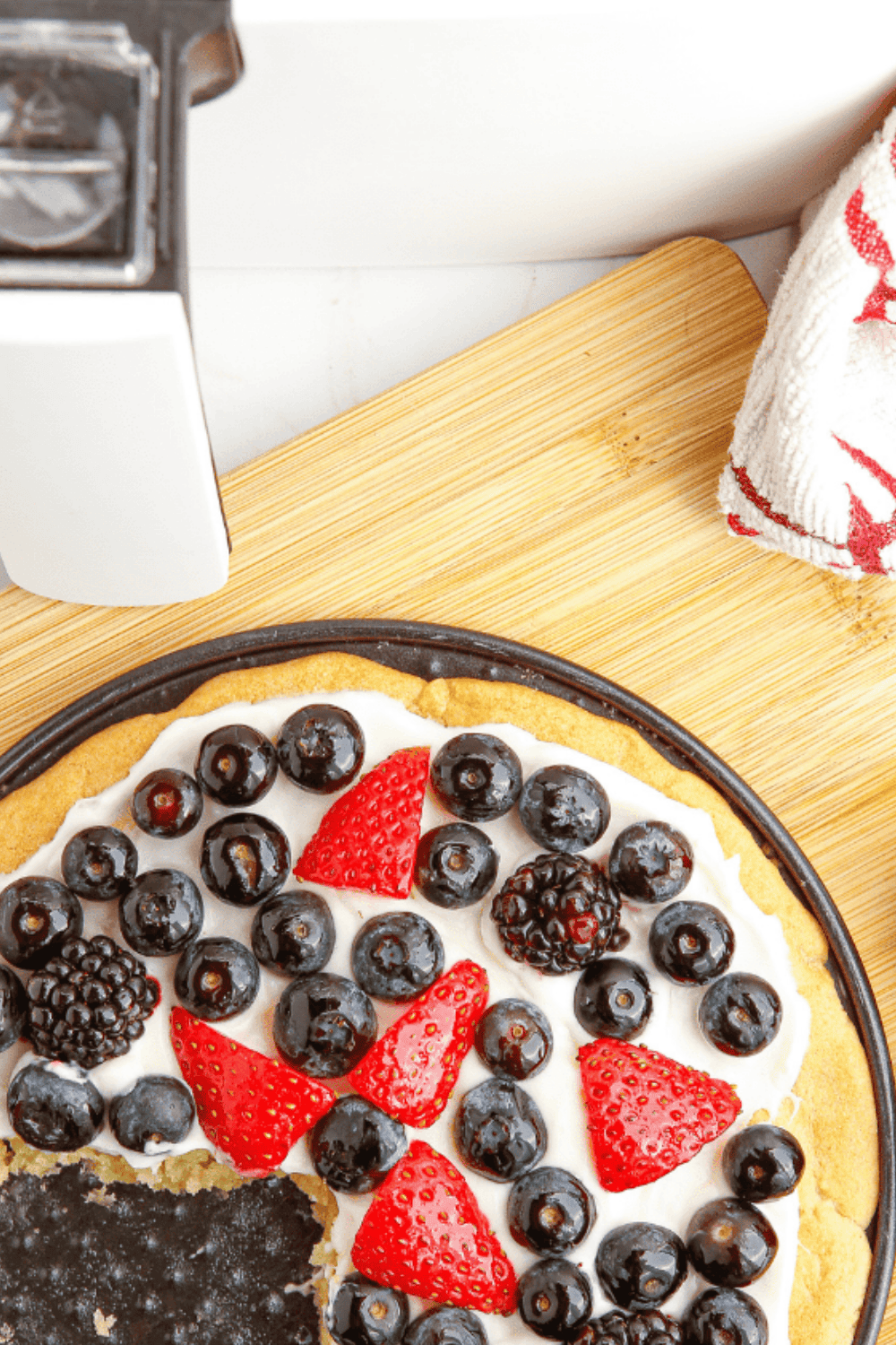 Air Fryer Sugar Fruit Pizza with golden cookie base, creamy frosting, and vibrant fresh fruit on top.