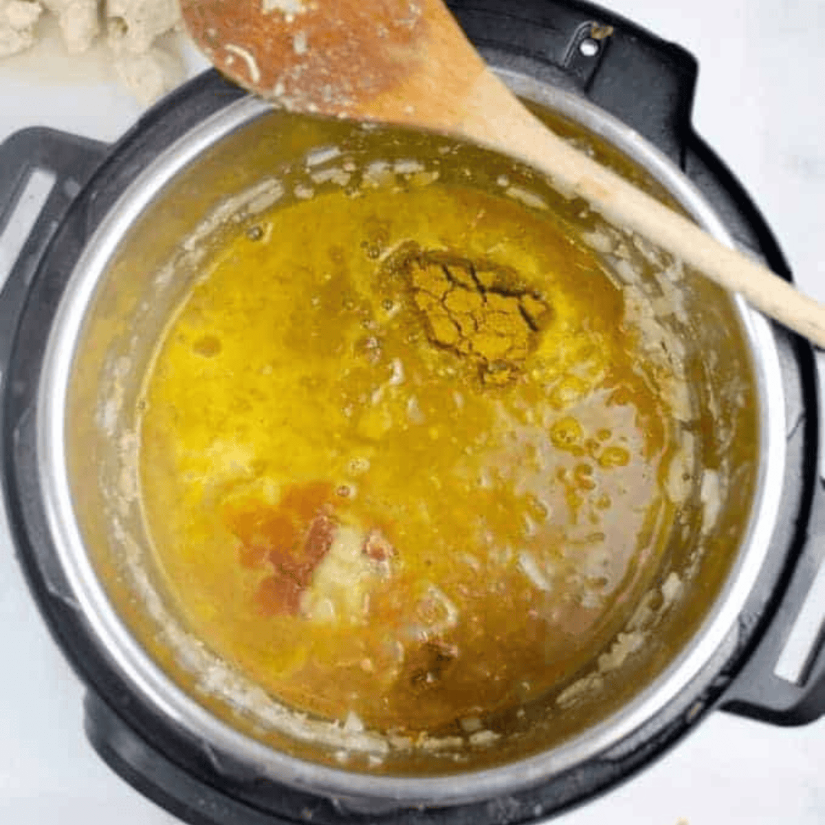 Coconut milk, curry powder, tomato paste, and spices poured over chicken in slow cooker.