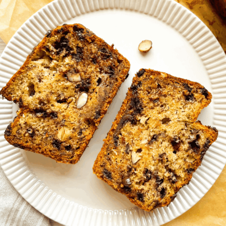 Air Fryer Almond Chocolate Banana Bread loaf topped with almonds and chocolate chunks, sliced and ready to serve.