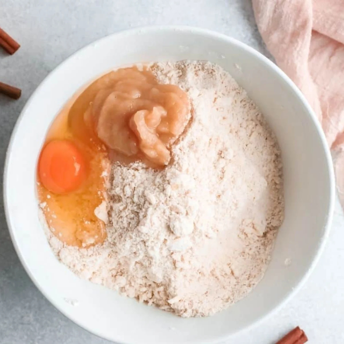 Whisking flour, sugar, baking powder, and cinnamon together in a large glass bowl